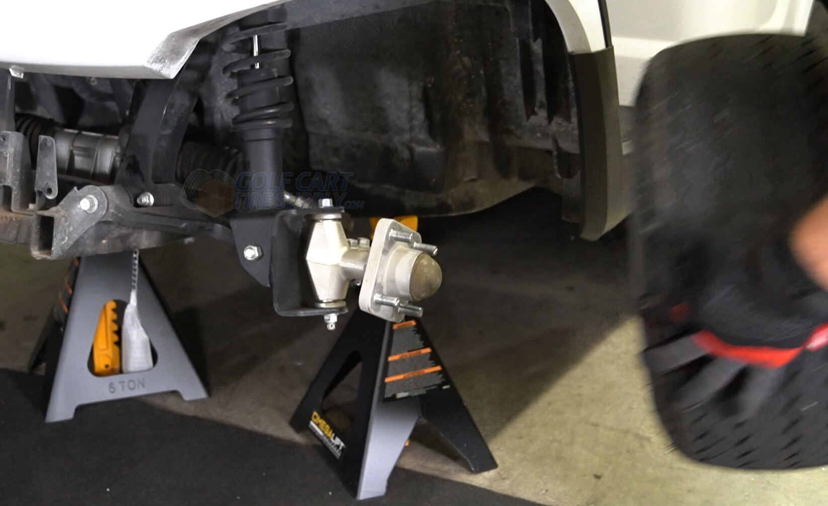 Golf Cart Tire and Wheel being removed from a Golf Cart